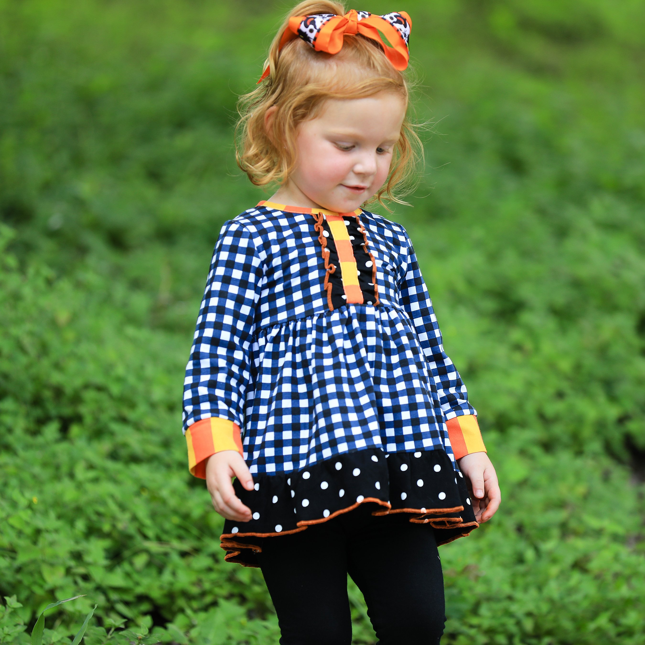 AnnLoren Girls Autumn outfit featuring a black and white gingham dress with polka dot ruffle trim and black leggings with ruffle trim.